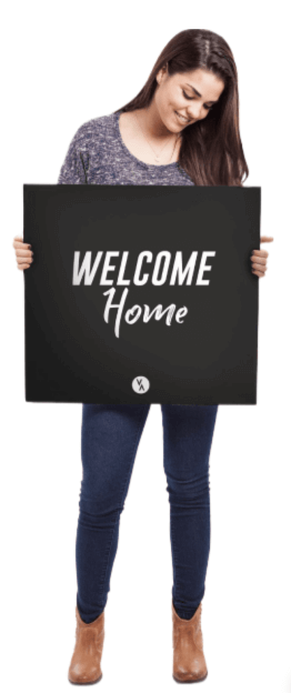 girl holding sign that says welcome home